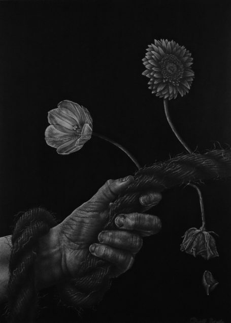 Hand houdt een touw vast met bloemen die eruit steken tegen een donkere achtergrond.